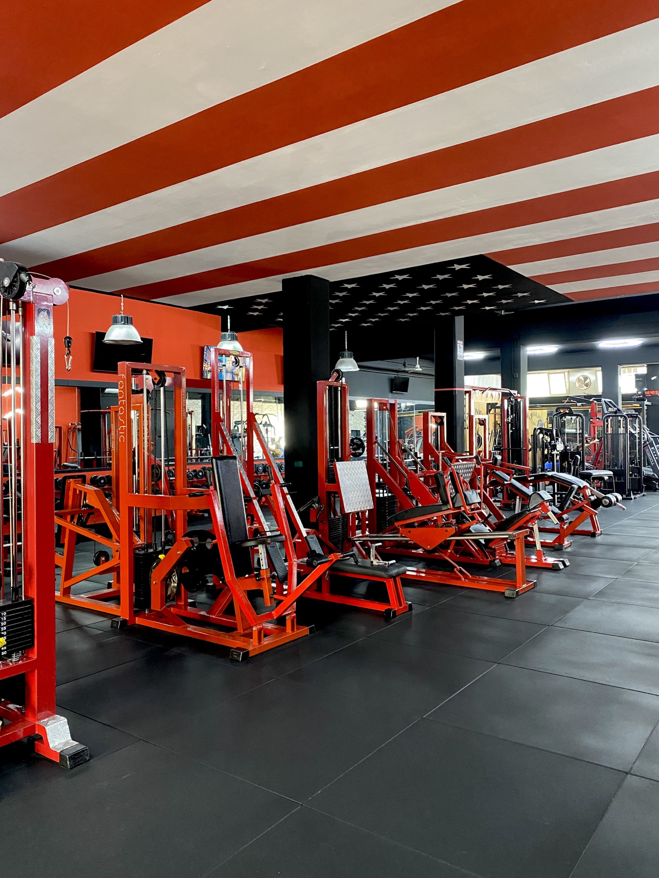 Planet Gym — sala macchine rossa sotto il soffitto a strisce