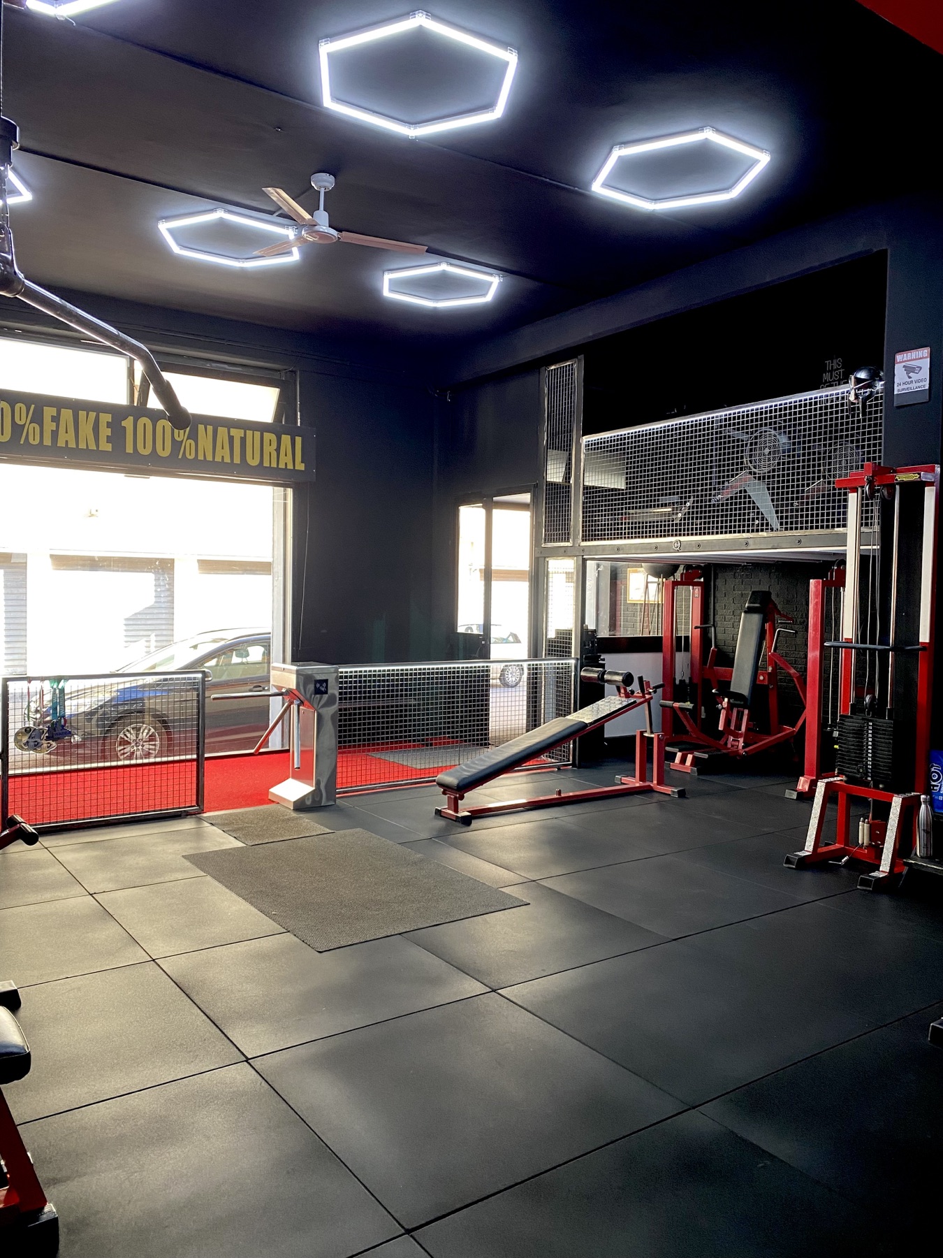Planet Gym — zona ingresso con panche e luci esagonali
